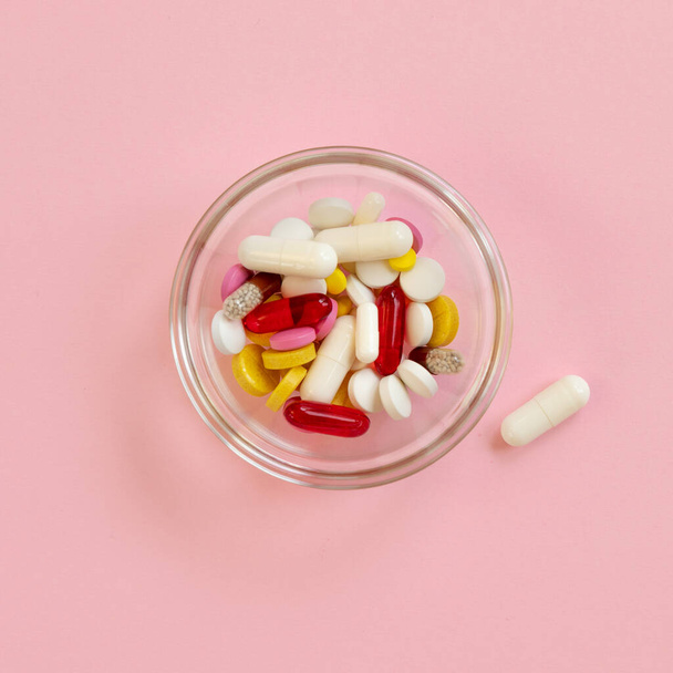 Multi-colored pills and capsules, tablets against the virus, flu, disease on pink background. Medical concept of Virus Pandemic Protection, Coronavirus. - Foto, afbeelding