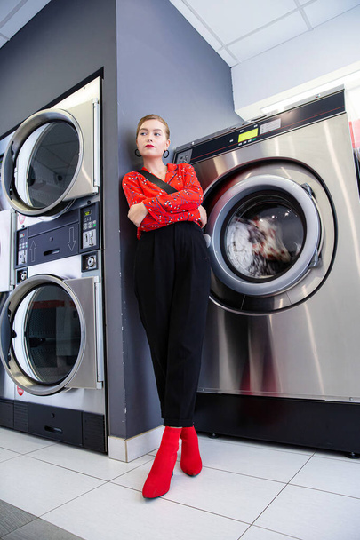 Young white woman standing with washing machine - Foto, imagen