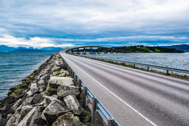 Strada 64 per Bolsoy Bridge o Bolsoybrua che attraversa lo stretto di Bolsoysund tra la terraferma e l'isola di Bolsoya. Molde. More og Contea di Romsdal, Norvegia. Paesaggio di ponte contro cielo nuvoloso blu. - Foto, immagini