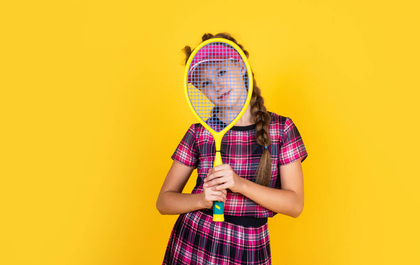 Relaxing after training. happy girl holding sport equipment. kid hold tennis racket. child wear fitness cap. childhood activity. healthy way of life. be energetic. badminton player with racquet - Foto, Imagen