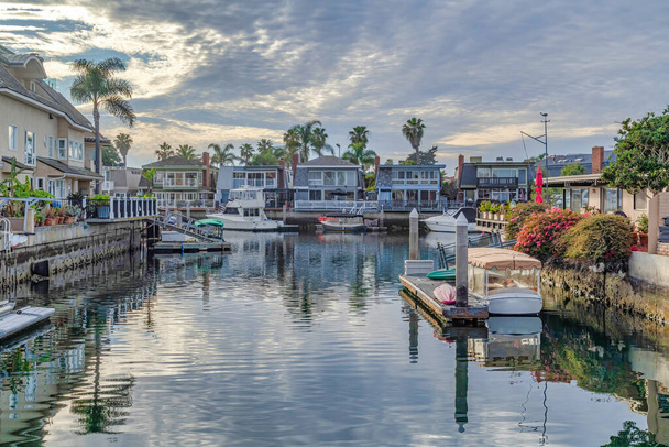 Sonnenuntergang in Huntington Beach mit Booten auf privaten Docks von Häusern am Wasser - Foto, Bild