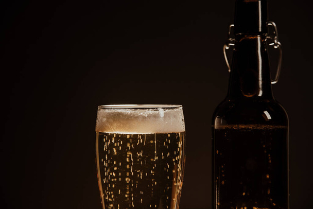 Макро бутылка пива и стакан пива на темном фоне - Фото, изображение
