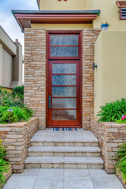 Drzwi frontowe ze szkliwionymi wstawkami i oknem przejściowym na elewacji domu - Zdjęcie, obraz