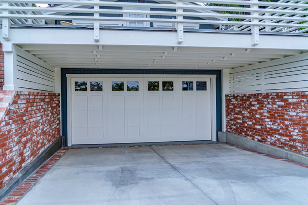 Белая дверь гаража под просторным балконом с белыми перилами в Сан-Диего, Калифорния - Фото, изображение