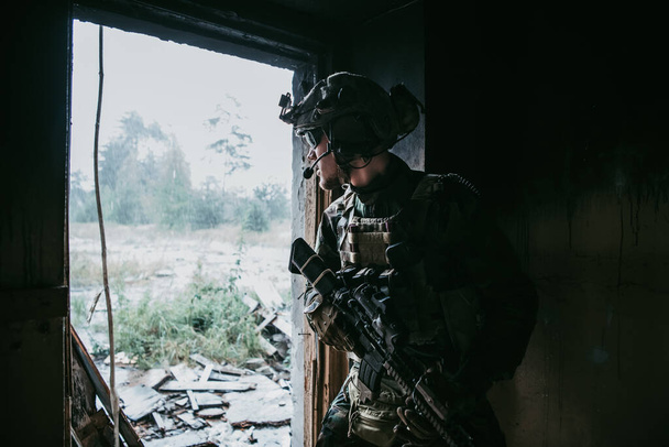 Military men with arms defending the building. Soldier stand guard securing territory looking around. - Photo, image