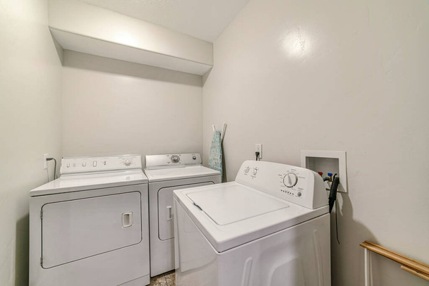 Kleine und minimalistische Waschküche des Hauses mit Waschmaschine und Trockner - Foto, Bild