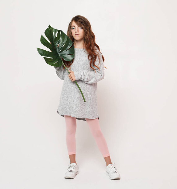 Beauty and fashion concept: Little curly girl child wearing casual outfit and holding flower - Фото, зображення