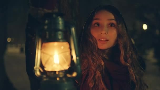 Chica joven con linterna en el bosque de invierno, caminando y mirando a su alrededor, anochecer, cuento de hadas - Imágenes, Vídeo