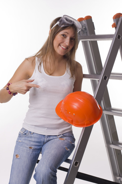 Menina com um capacete de construção em uma escada
 - Foto, Imagem