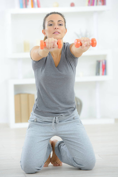 a lady exercising holding dumbbells - Foto, Imagen