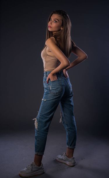 Studio body shot of a trendy woman wearing modern skinny pants - 写真・画像