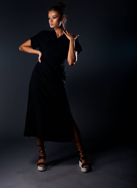 Portret van een aantrekkelijke stijlvolle vrouw poseren tegen donkere achtergrond - Foto, afbeelding
