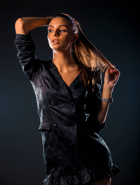 Portrét krásné stylové ženy pózující v sukni proti tmavému pozadí - Fotografie, Obrázek