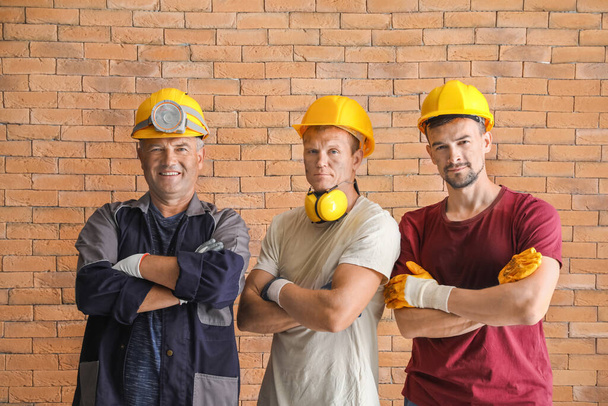Miner men on brick background - Fotó, kép