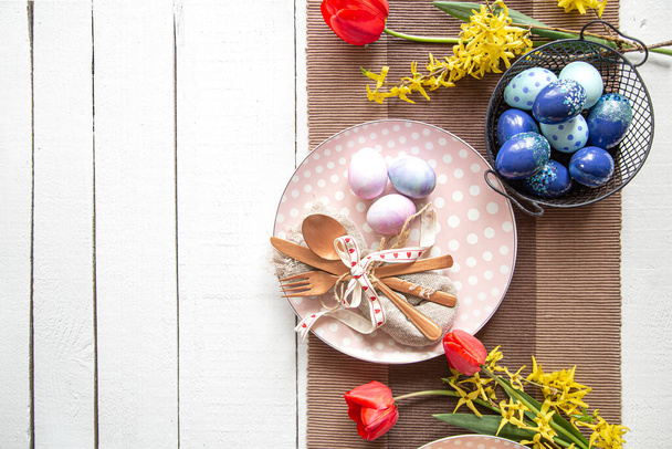 Teller mit Osterkuchen, Blumen und Ostereiern. Tischdekoration für die Osterfeiertage. - Foto, Bild