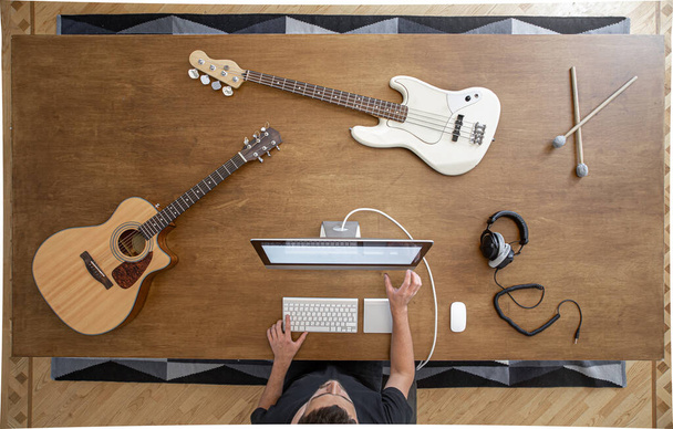 Vue de dessus d'une composition d'instruments de musique sur une table en bois dans un studio d'enregistrement. Lieu de travail du musicien pour la créativité. - Photo, image