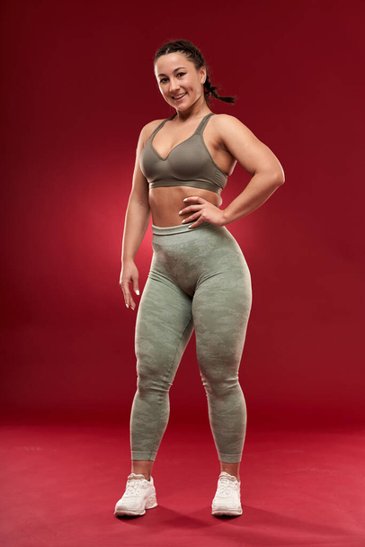 Confident plus size young woman in fitness attire exercising at studio  - Fotoğraf, Görsel