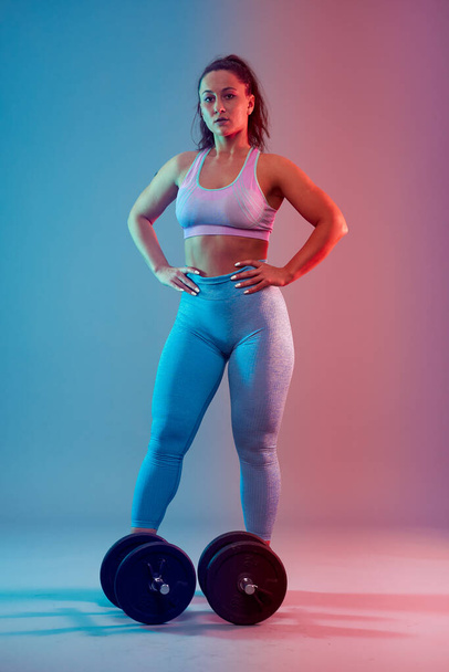 Confident plus size young woman in fitness attire exercising at studio  - Foto, Imagen