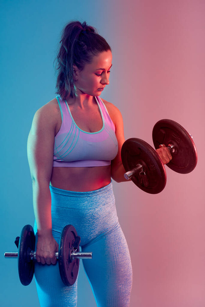 Confident plus size young woman in fitness attire exercising at studio  - Foto, Imagem