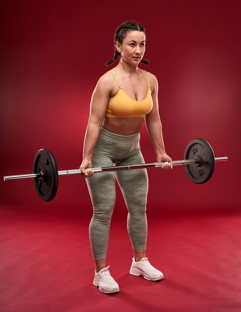 Confident plus size young woman in fitness attire exercising at studio  - Photo, Image