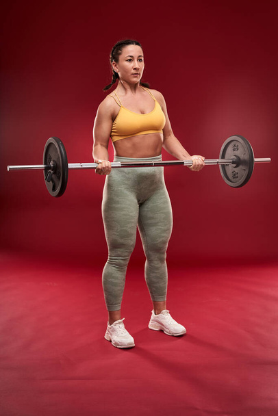 Confident plus size young woman in fitness attire exercising at studio  - Photo, Image