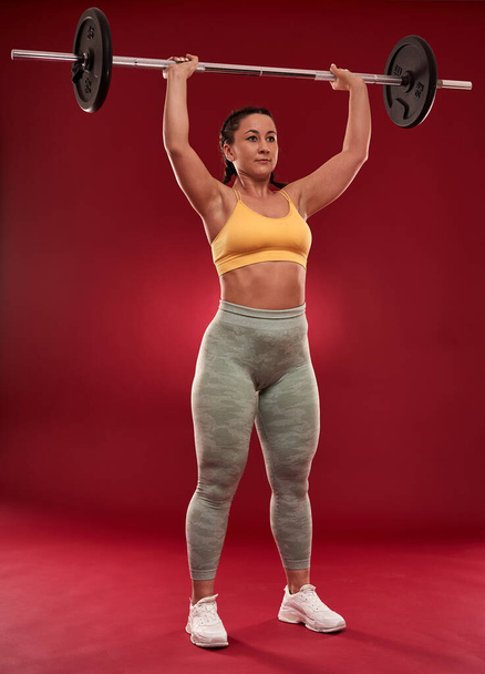Confident plus size young woman in fitness attire exercising at studio  - Foto, Imagem