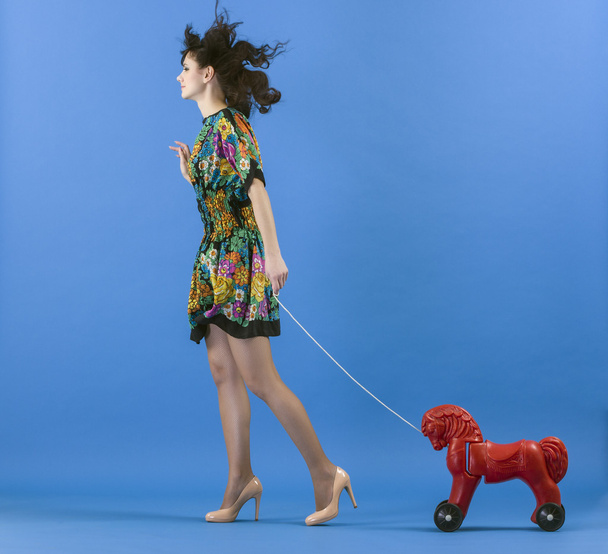 Young woman with toy horse - 写真・画像