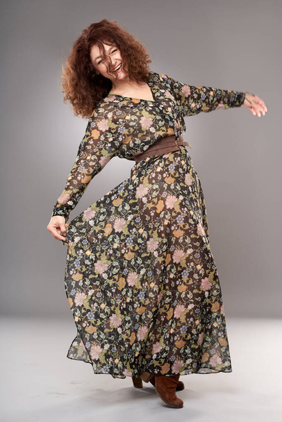 Beauty at 50. Studio portrait of a mature curly haired woman in long dress - 写真・画像