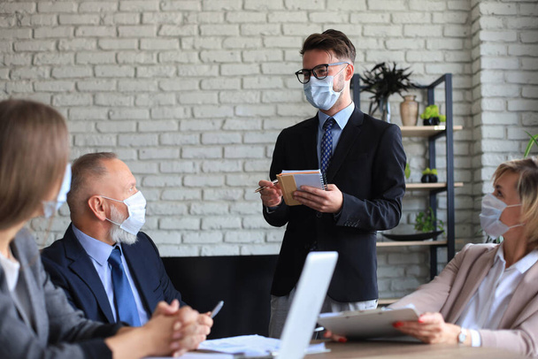 保護マスクのビジネスチームはオフィスで働く - 写真・画像