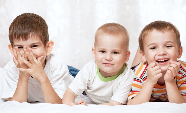 drei Jungen liegen auf dem Bett - Foto, Bild