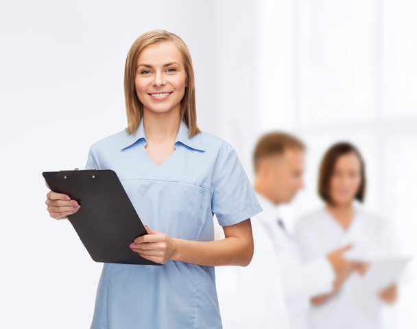 Médico o enfermera sonriente con portapapeles
 - Foto, Imagen