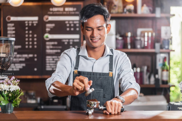 Asian Barista tamping the portafilter and preparing cup of coffee, espresso with latte or cappuccino for customer order in coffee shop, Μικρές επιχειρήσεις και startup in coffee shop concept - Φωτογραφία, εικόνα