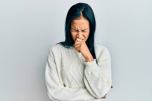 Krásná hispánská žena na sobě ležérní zimní svetr přes bílé pozadí pocit nevolnosti a kašel jako symptom pro nachlazení nebo zánět průdušek. koncepce zdravotní péče.  - Fotografie, Obrázek