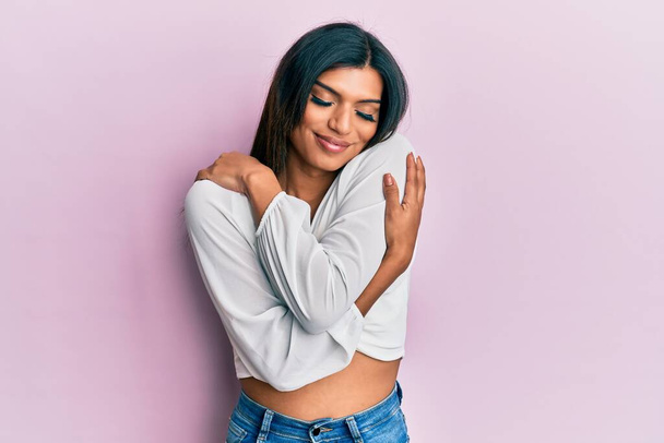 Young latin transsexual transgender woman wearing casual clothes hugging oneself happy and positive, smiling confident. self love and self care  - Фото, зображення