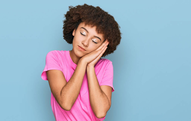 Young hispanic girl wearing casual clothes sleeping tired dreaming and posing with hands together while smiling with closed eyes.  - Foto, Imagem