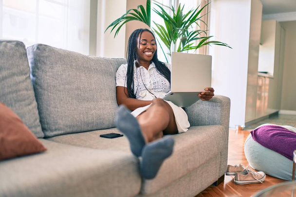 Young african american woman smiling happy working using laptop at home - Foto, Imagen