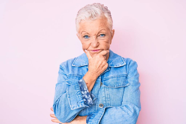 Senior beautiful woman with blue eyes and grey hair wearing casual denim jacket thinking looking tired and bored with depression problems with crossed arms.  - Foto, Bild