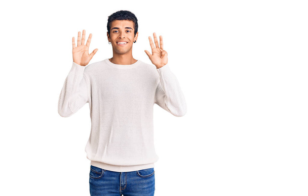 自信を持って幸せな笑顔ながら、若いアフリカ系アメリカ人の男性は、カジュアルな服を着て指の数9で示すと指摘します.  - 写真・画像