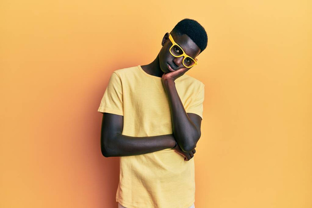 Jovem afro-americano vestindo roupas casuais e óculos pensando que parece cansado e entediado com problemas de depressão com os braços cruzados.  - Foto, Imagem