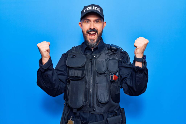 Молодий красивий чоловік у поліцейській формі кричить гордо, святкуючи перемогу і успіх дуже схвильований піднятими руками
  - Фото, зображення