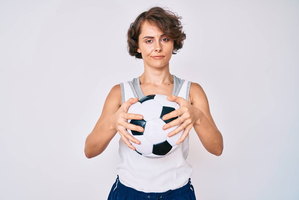 Νεαρή Ισπανίδα που κρατάει την μπάλα χαλαρή με σοβαρή έκφραση στο πρόσωπο. απλή και φυσική κοιτάζοντας την κάμερα.  - Φωτογραφία, εικόνα