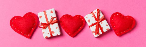 Horní pohled barevné valentýnské pozadí z dárkových krabic a červených textilních srdcí. Valentýn koncept s kopírovacím prostorem. - Fotografie, Obrázek