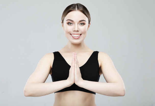 Young Woman practicing yoga, close up, hands together. Over light grey background. - Foto, afbeelding
