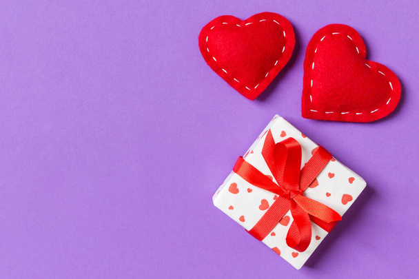 Holiday composition of gift boxes and red textile hearts on colorful background with empty space for your design. Top view of Valentine's Day concept. - 写真・画像