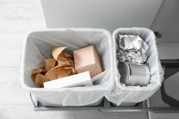 Offener Schrank mit vollen Mülleimern für die getrennte Müllabfuhr in der Küche, oben Ansicht - Foto, Bild
