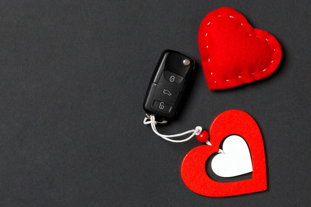 Top view of car key, wooden and textile heart on colorful background. Luxury present for Valentine's day. - Photo, Image