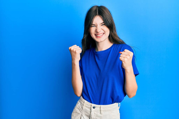 Young beautiful caucasian girl wearing casual clothes celebrating surprised and amazed for success with arms raised and eyes closed  - Foto, Bild