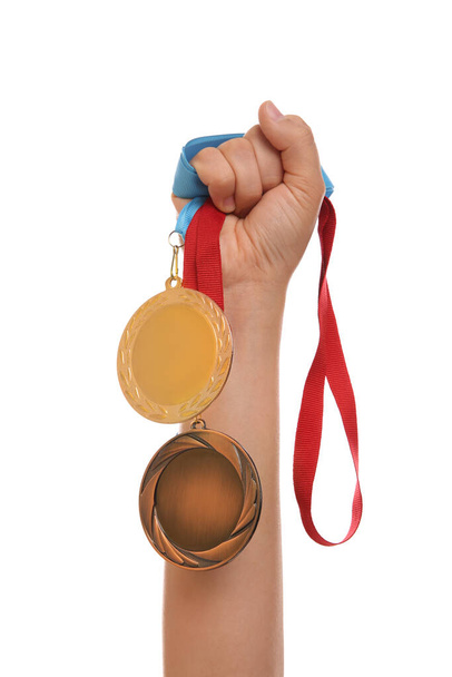 Woman holding gold and bronze medals on white background, closeup - Foto, Imagen
