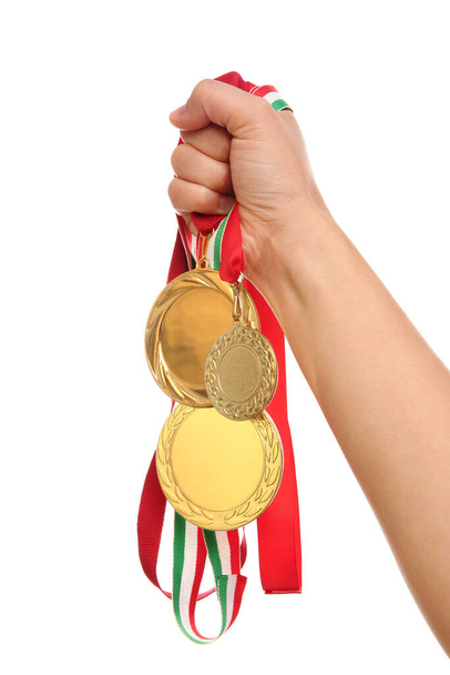 Woman holding gold medals on white background, closeup - Foto, Imagem