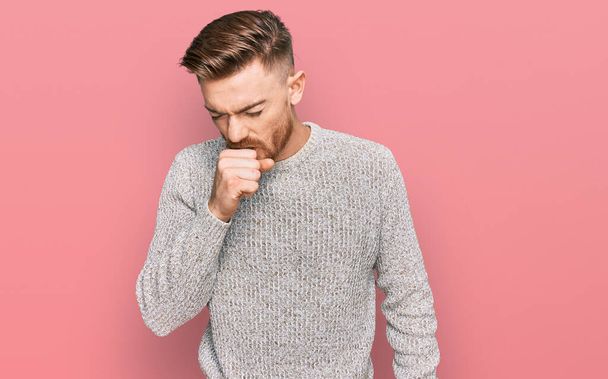Young redhead man wearing casual winter sweater feeling unwell and coughing as symptom for cold or bronchitis. health care concept.  - Photo, Image